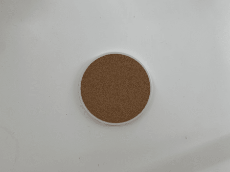 <b>Coaster Back</b><br>I photographed the back of the coaster with my phone, revealing the natural texture of the wood chip material. I chose this object because it is a simple flat cylinder with a unique wood chip texture on the back.