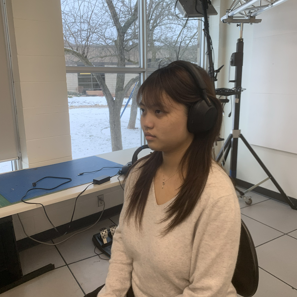 <b>Wearing Headphones</b><br>Here I am wearing a pair of sleek, over-ear headphones. They comfortably encase my ears, isolating me from outside sounds as I sit attentively.