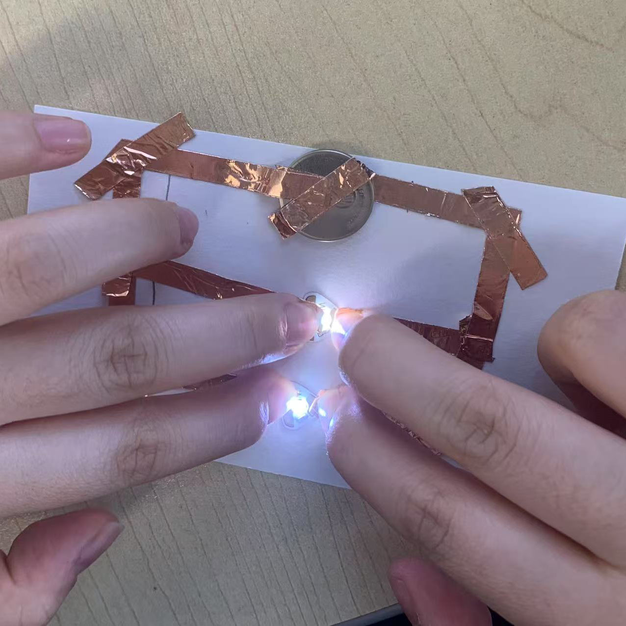 I pressed the connections to test the parallel circuit. Both LEDs glowed brightly, confirming the design works perfectly.