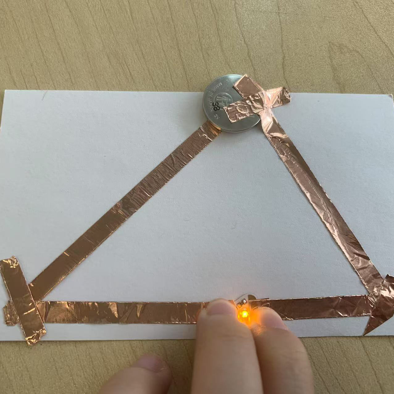 The triangular circuit was finalized with all components securely in place. It demonstrates a creative design approach with proper functionality.
