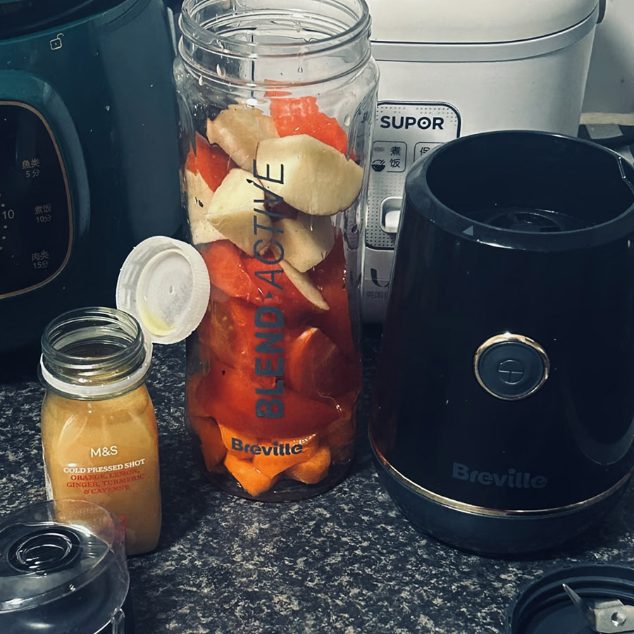 A blender filled with fruits, depicting the loud blending noise as it purees its contents.