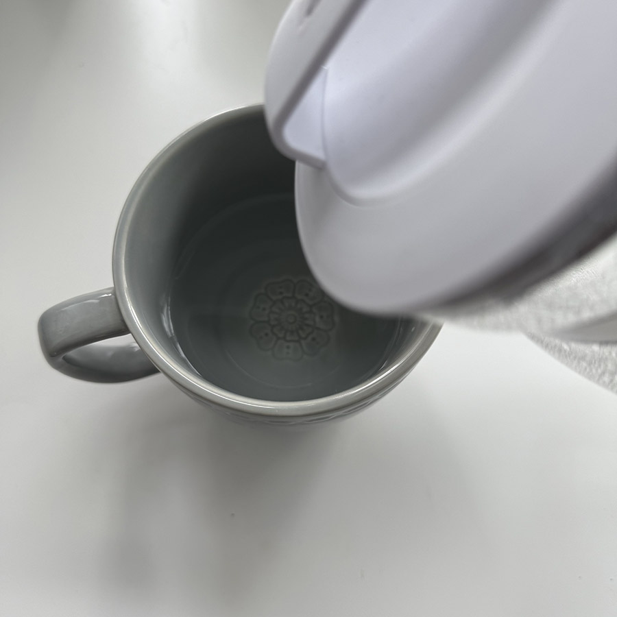 Water being poured from a kettle into a mug, illustrating the fluid sound of water flowing from one container to another.