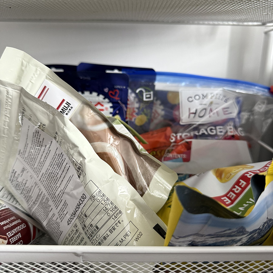 An open drawer filled with various snack packages, illustrating the sound of rustling plastic and packaging as someone searches through it.