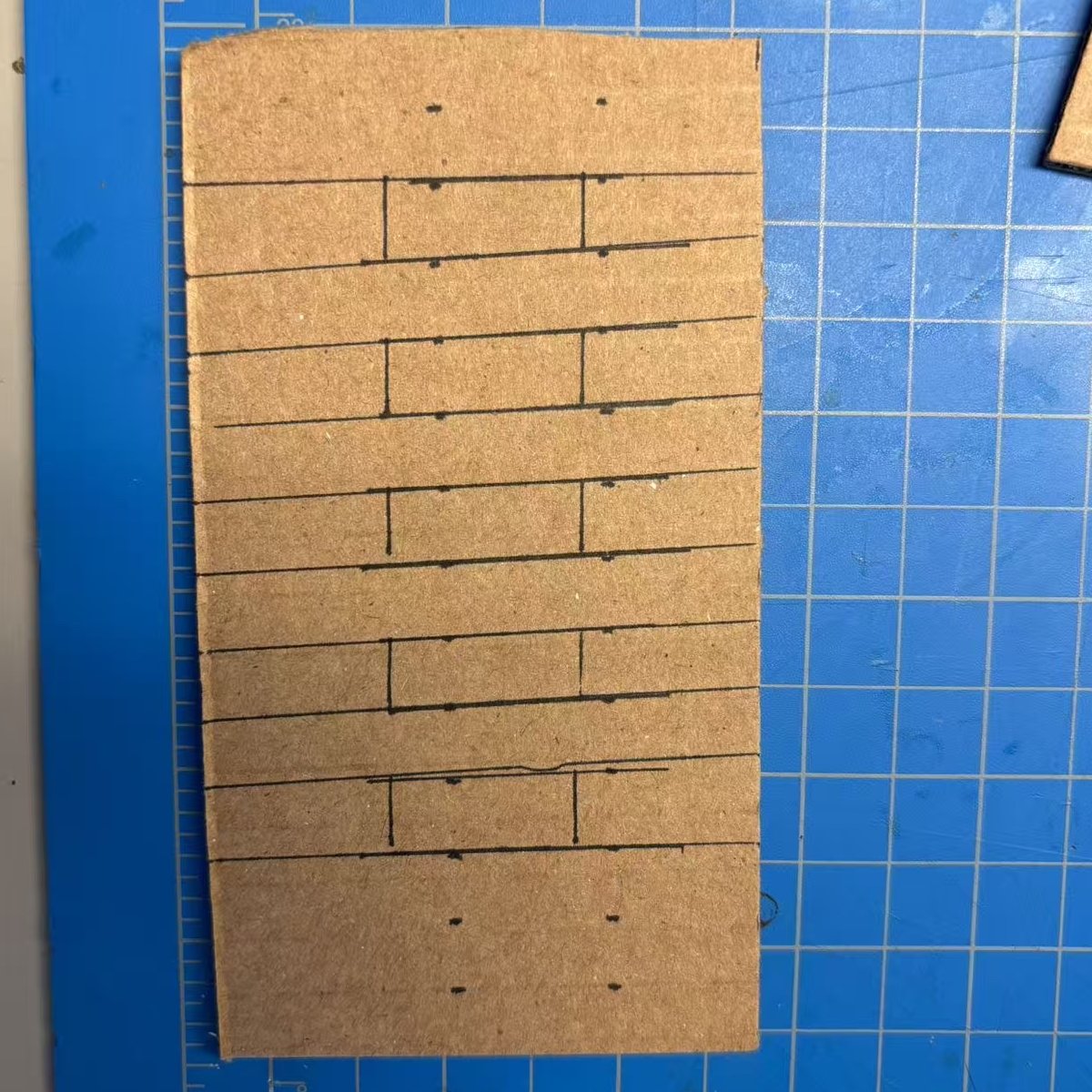 <b>Drawing and Measuring</b><br>We start by marking lines on the cardboard to plan the shape of our phone stand, and we measure each part carefully so every piece will fit together correctly.