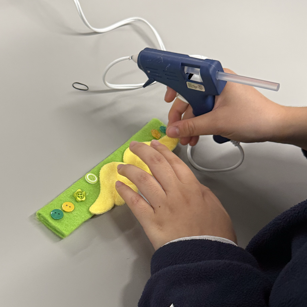 <b>Assembling the Wrist Band</b><br>We decorated and assembled the wrist band by attaching felt and buttons with hot glue. This step allowed us to make the sensor wearable and comfortable, while also keeping the pulse sensor hidden under the fabric.